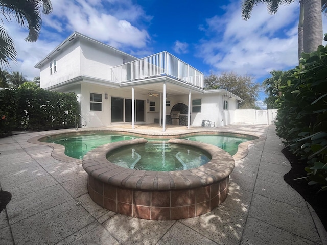 view of swimming pool featuring a patio, a pool with connected hot tub, fence, and a ceiling fan