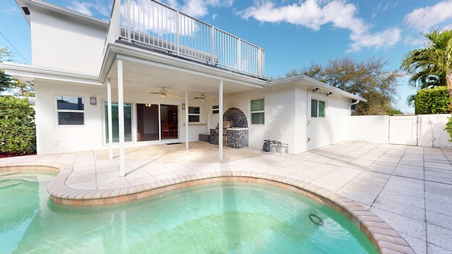 back of house featuring stucco siding, a ceiling fan, a patio area, fence, and a balcony