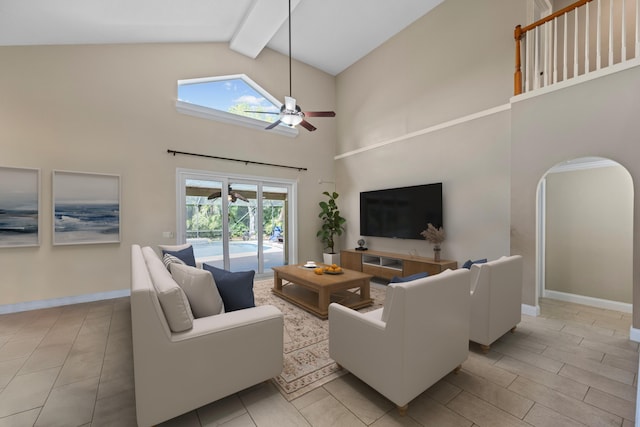 living area featuring ceiling fan, beam ceiling, high vaulted ceiling, arched walkways, and baseboards