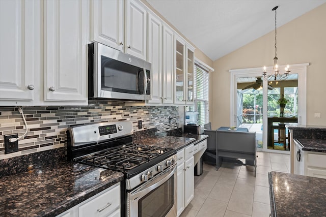 kitchen featuring stainless steel appliances, vaulted ceiling, backsplash, white cabinetry, and a chandelier