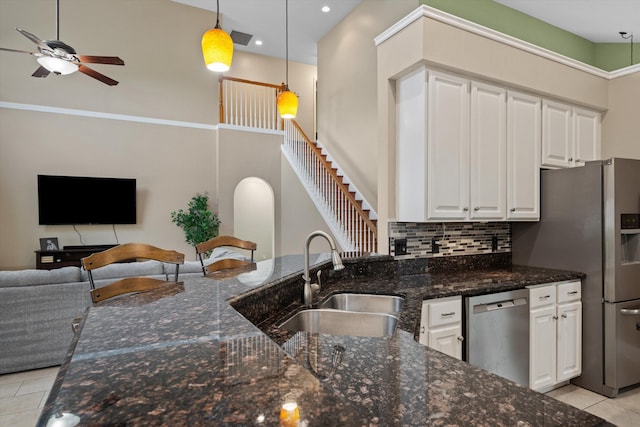 kitchen with appliances with stainless steel finishes, open floor plan, a sink, light tile patterned floors, and ceiling fan