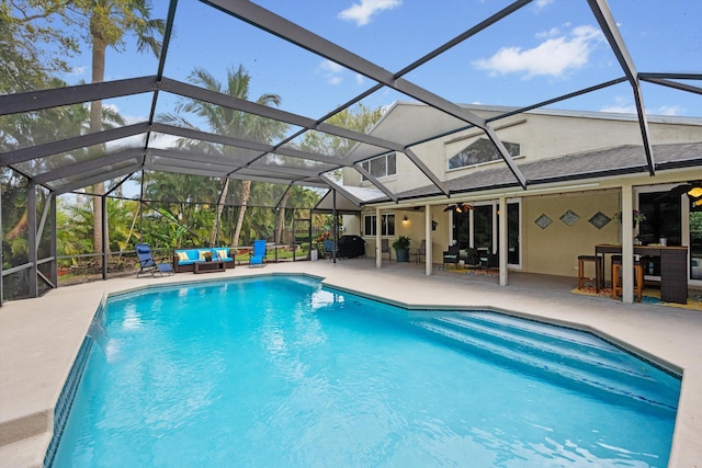 outdoor pool with an outdoor hangout area, a patio, a lanai, and a ceiling fan