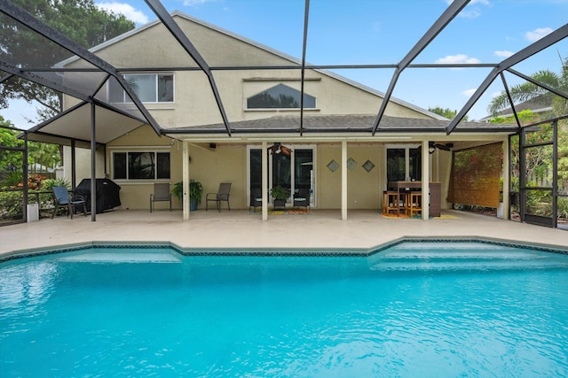 outdoor pool with a patio, a lanai, and ceiling fan