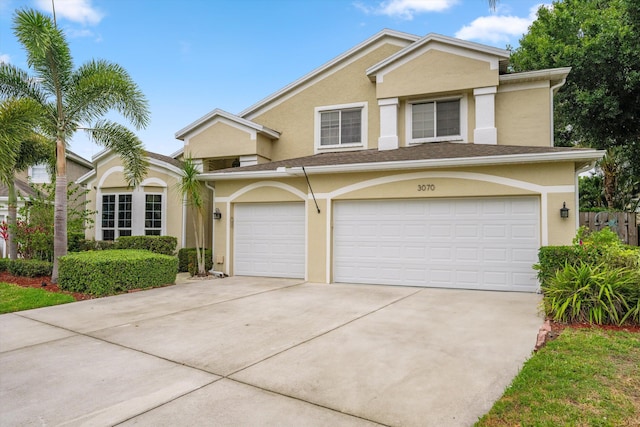 view of property with stucco siding, concrete driveway, and a garage