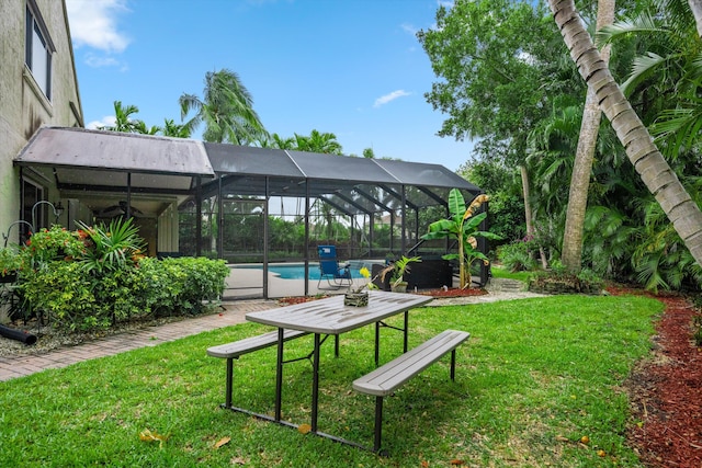 view of green lawn featuring an outdoor pool, a ceiling fan, and a lanai