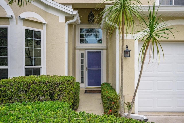 entrance to property featuring stucco siding and an attached garage