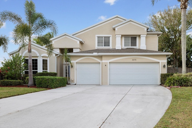 view of front of house featuring driveway, a garage, and stucco siding