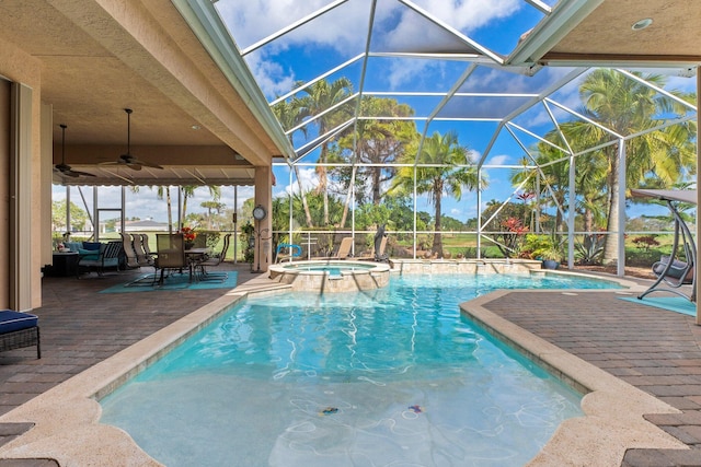 view of pool with a lanai, a pool with connected hot tub, and a ceiling fan