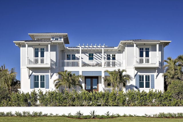 exterior space featuring french doors, metal roof, a balcony, and a standing seam roof