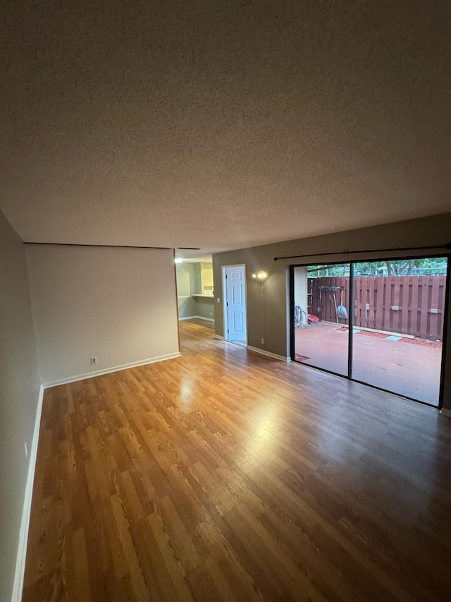 1458 N Lawnwood Cir Unit 23A, Fort Pierce, FL 34950 - unfurnished room with wood finished floors, a textured ceiling, and baseboards
