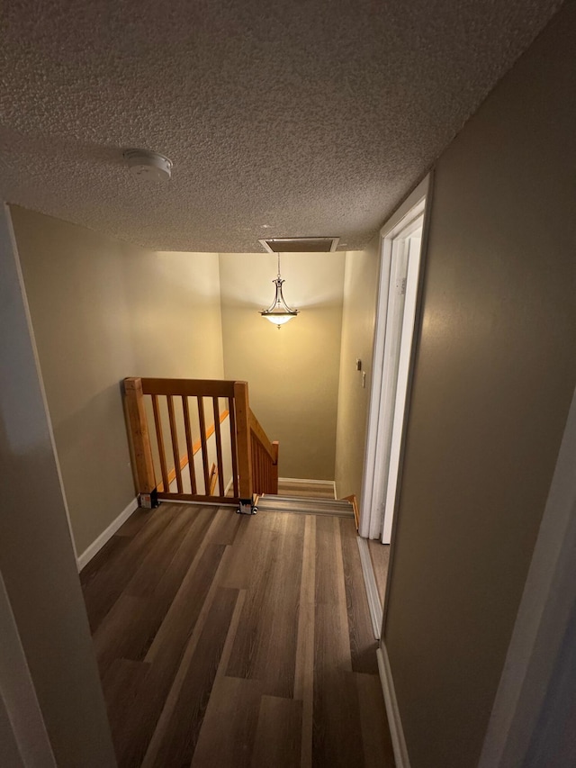 1458 N Lawnwood Cir Unit 23A, Fort Pierce, FL 34950 - hallway featuring an upstairs landing, baseboards, wood finished floors, and a textured ceiling