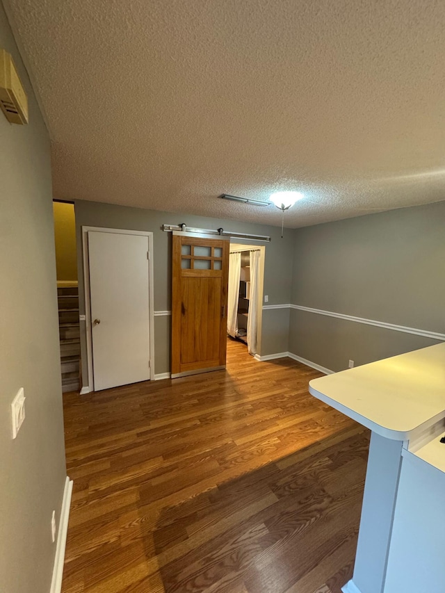 1458 N Lawnwood Cir Unit 23A, Fort Pierce, FL 34950 - empty room with wood finished floors, a textured ceiling, baseboards, and stairs
