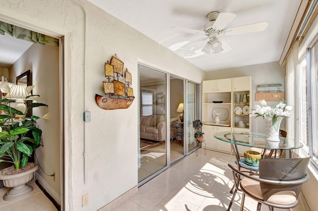 sunroom / solarium featuring a ceiling fan