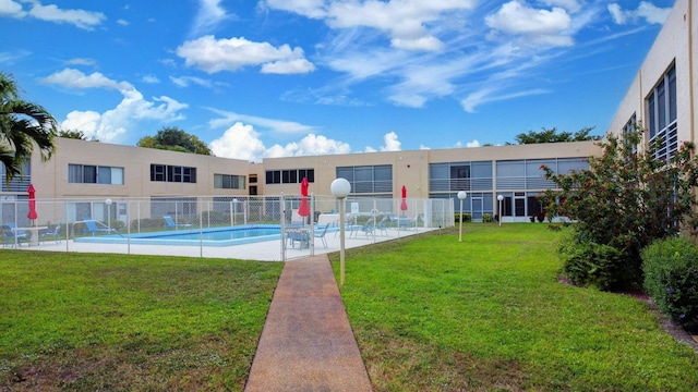 community pool with fence, a patio, and a yard