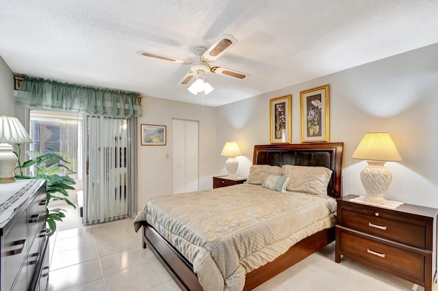 bedroom with a ceiling fan, access to exterior, a textured ceiling, a closet, and light tile patterned flooring