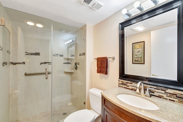 bathroom with toilet, visible vents, vanity, backsplash, and a shower stall