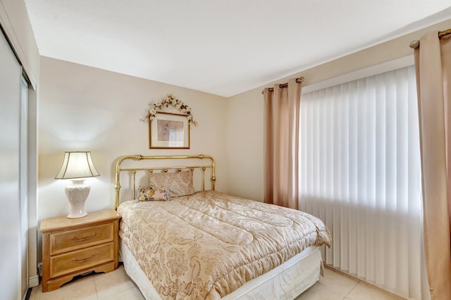 bedroom with light tile patterned floors and a closet