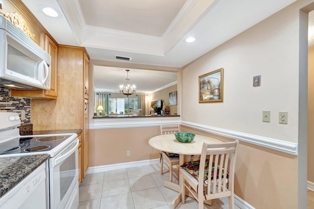 kitchen featuring white appliances, a raised ceiling, visible vents, and crown molding