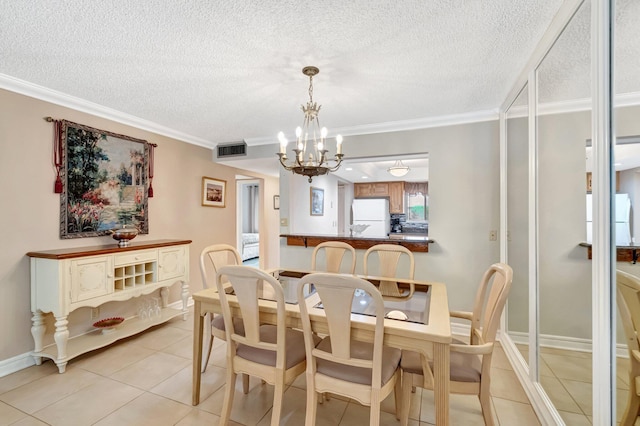 dining area featuring light tile patterned floors, a textured ceiling, a notable chandelier, visible vents, and crown molding