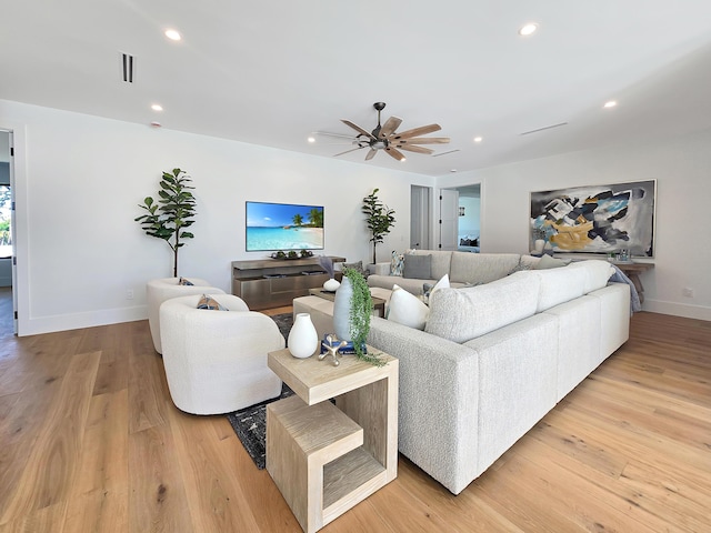 living room with baseboards, ceiling fan, light wood-type flooring, and recessed lighting