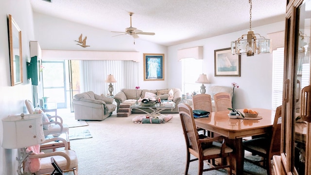 carpeted dining space featuring lofted ceiling, a ceiling fan, and a textured ceiling