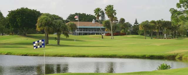 view of home's community featuring a water view, golf course view, and a yard