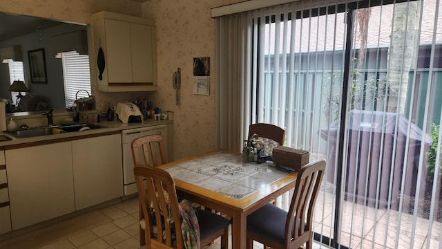 dining space featuring wallpapered walls and light tile patterned flooring