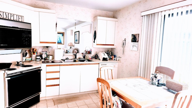 6764 SE Bunker Hill Dr, Hobe Sound, FL 33455 - kitchen featuring light countertops, a sink, range with electric stovetop, wallpapered walls, and white cabinets