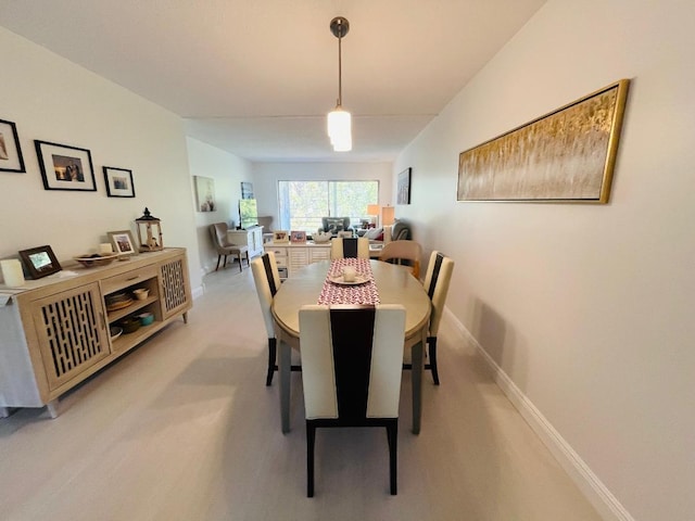 dining space with light carpet and baseboards