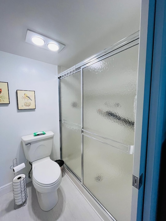 bathroom with a shower stall and toilet