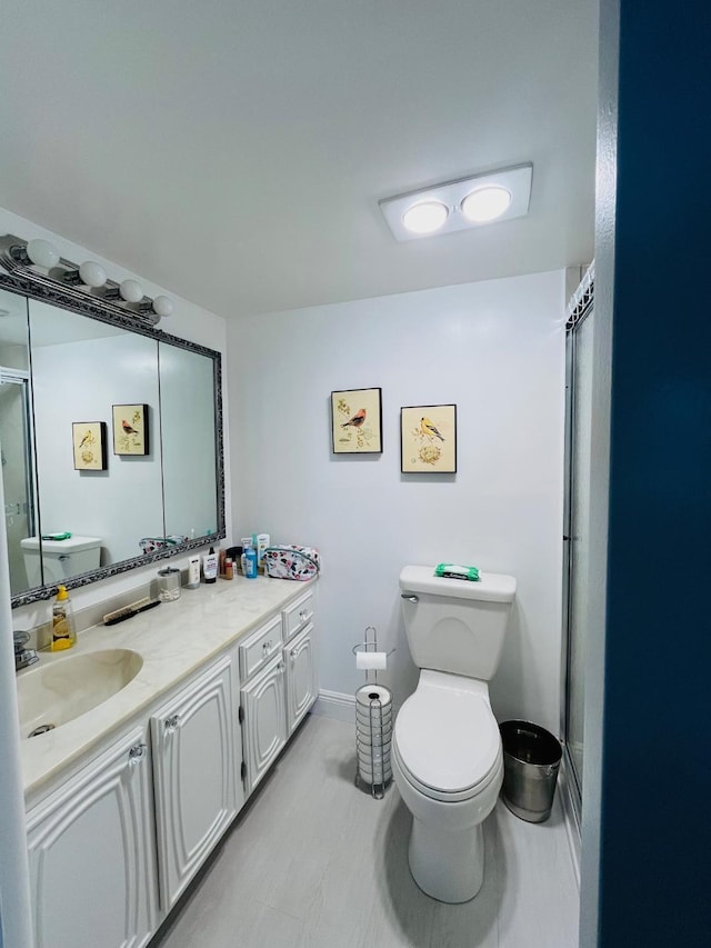 full bathroom featuring toilet, vanity, and baseboards