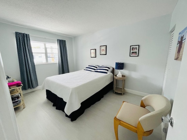 bedroom with carpet, a textured ceiling, and baseboards