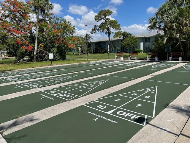 view of home's community with shuffleboard and a yard