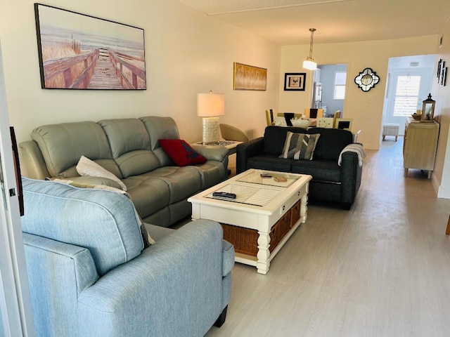 living room with light wood-type flooring and baseboards