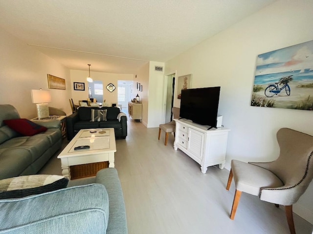 living room featuring light wood-style flooring and visible vents