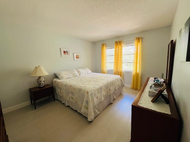 bedroom with a textured ceiling and baseboards