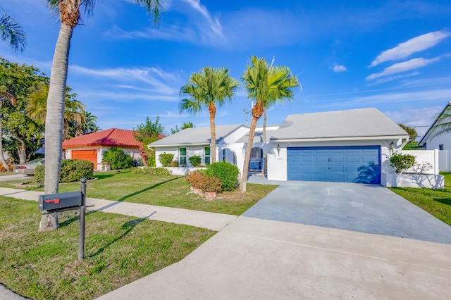 single story home with a garage, fence, concrete driveway, stucco siding, and a front yard