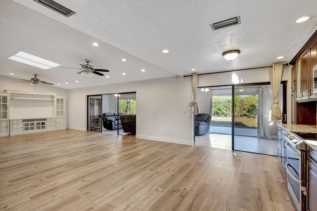 living area featuring recessed lighting, a skylight, visible vents, and light wood-style floors