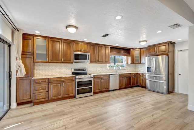 kitchen featuring brown cabinets, visible vents, and stainless steel appliances