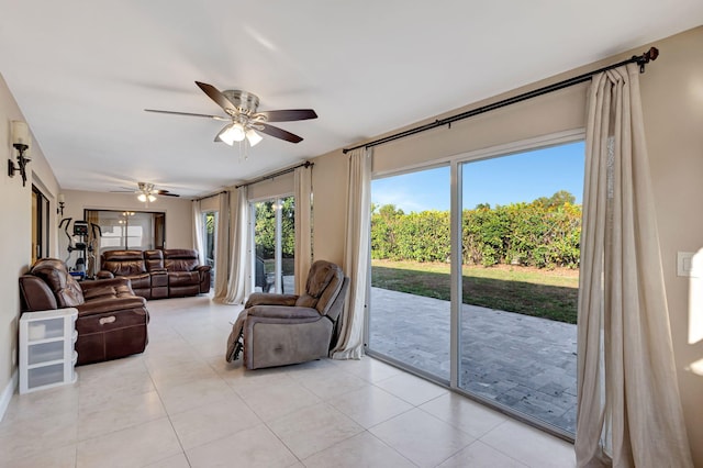 living area with a ceiling fan and light tile patterned floors