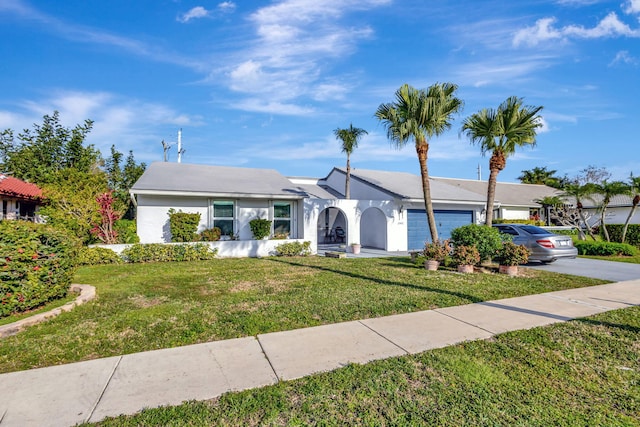 ranch-style house with a front lawn, driveway, an attached garage, and stucco siding