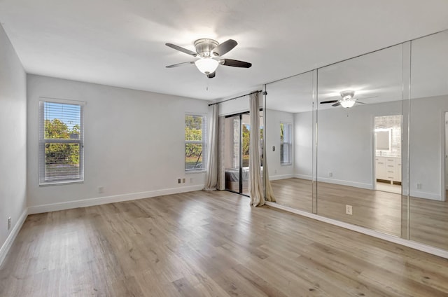 unfurnished bedroom featuring a ceiling fan, baseboards, connected bathroom, and light wood finished floors