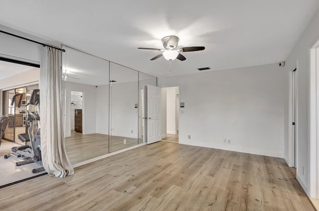 unfurnished bedroom with a ceiling fan, light wood-type flooring, visible vents, and baseboards