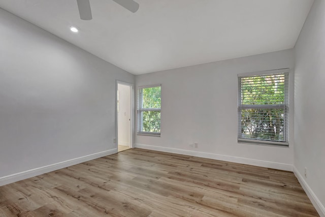 empty room with lofted ceiling, baseboards, wood finished floors, and recessed lighting