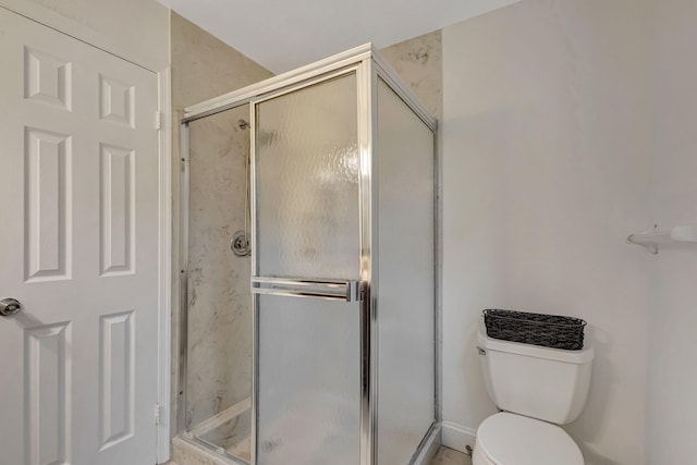 bathroom with a shower stall and toilet