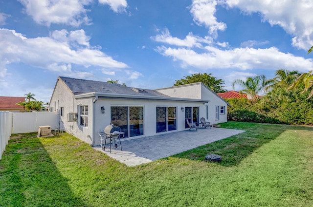 back of house with a yard, a patio area, a fenced backyard, and stucco siding