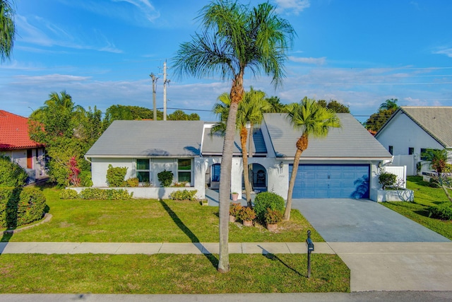 view of front of house with a garage, fence, driveway, stucco siding, and a front lawn