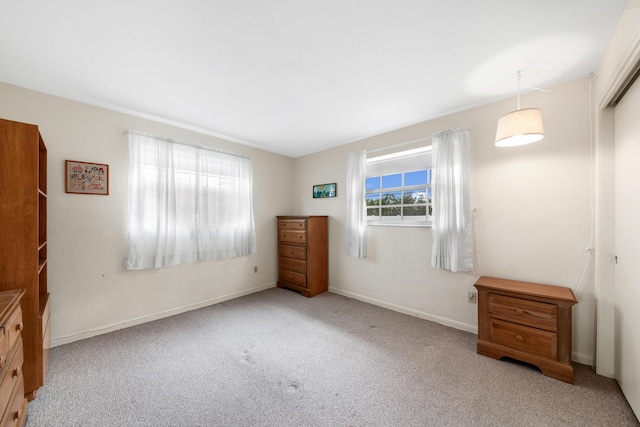 unfurnished bedroom with a closet, baseboards, and carpet flooring