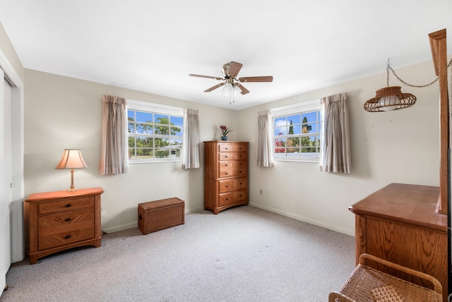 living area featuring carpet flooring, ceiling fan, and baseboards