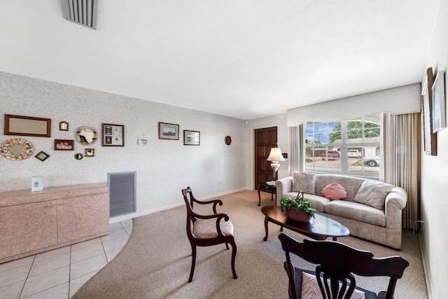 living area featuring light carpet, light tile patterned floors, baseboards, and visible vents